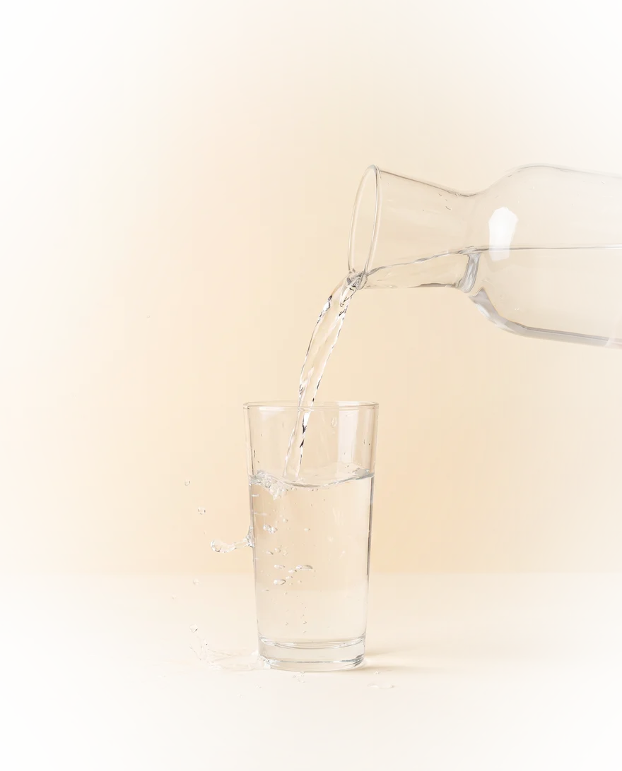 Water wordt in een hoog glas geschonken