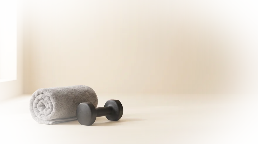 Opgerolde handdoek en dumbbell op een lichte vloer